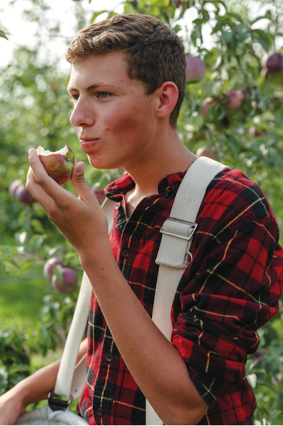 Charlie Fahey samples an apple while harvesting